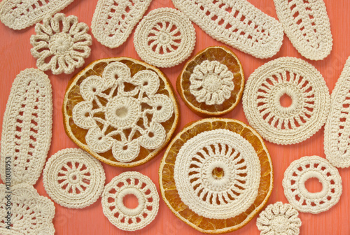 Dry oranges and white vintage elements of Irish crochet. Doilies, circle coasters, creative craft work