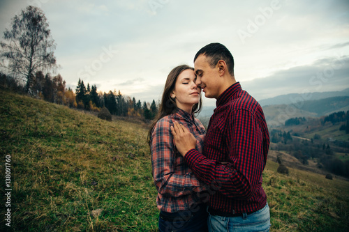 Beautiful loving couple in hipster fashion style posing on mountain