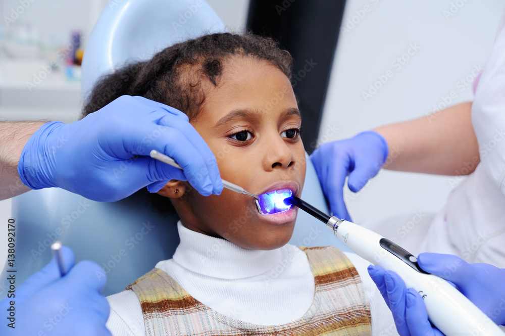 a dark-skinned baby girl in the dentist's chair a dark-skinned baby girl in the dentist's chair