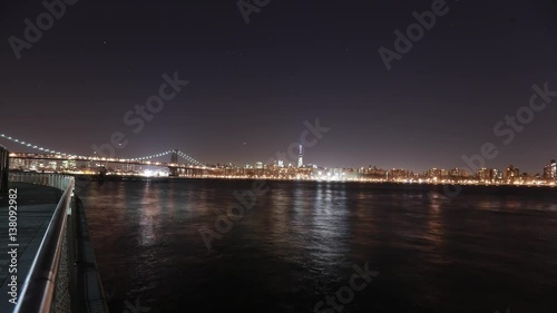 USA, New York City, Manhattan's financial district, and the Brooklyn Bridge with ships and planes passing by - night time-lapse