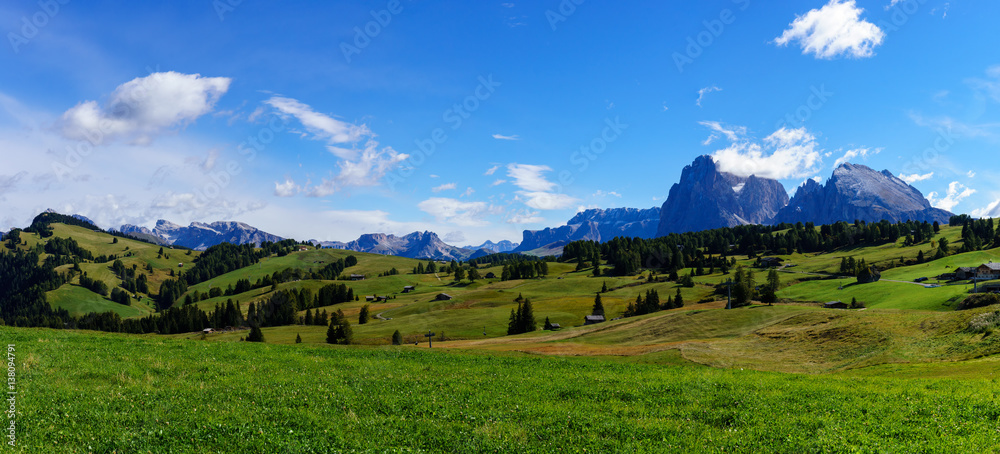 Panorama image of the Seiser Alm or Alpe di Siusi, a high altitude alpine meadow in the Dolomites with Langkofel and Plattkofel mountains under a layer of snow in winter in South Tyrol, Italy.