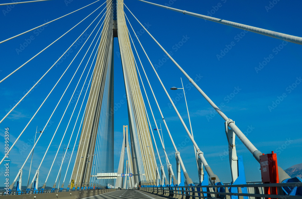 Obraz premium view of Rio Antirio bridge, one of the the world's longest cable bridges.It crosses the Gulf of Corinth and links the town of Rio on the Peloponnese peninsula to Antirrio on mainland Greece by road.