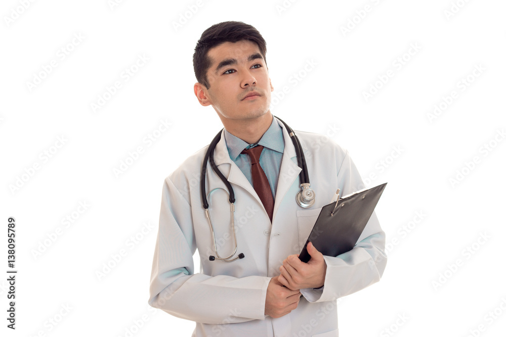 young beautiful brunette man doctor in uniform with stethoscope on his shoulders make notes isolated on white background young beautiful brunette man doctor in uniform with stethoscope on his shoulders make notes isolated on white background