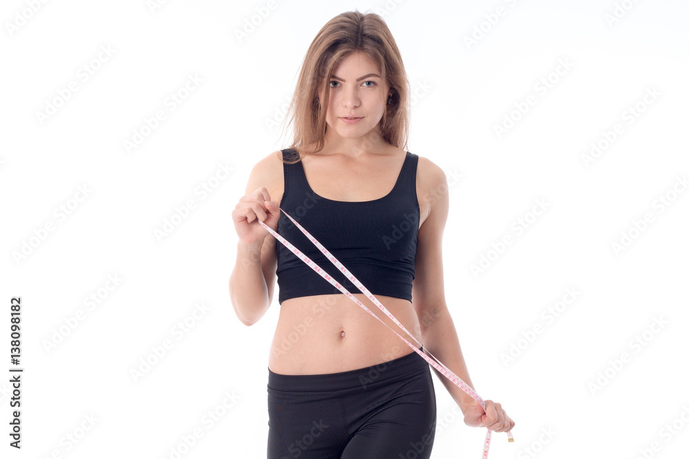 athletic girl who stands up straight and holds a tape measure athletic girl who stands up straight and holds a tape measure