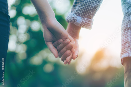 Close up of a couple holding hands.