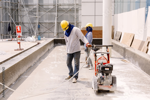 construction worker  was Cutting  oncrete in construction zone photo