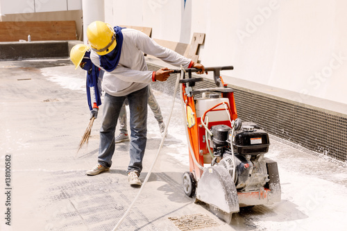 construction worker  was Cutting  oncrete in construction zone photo