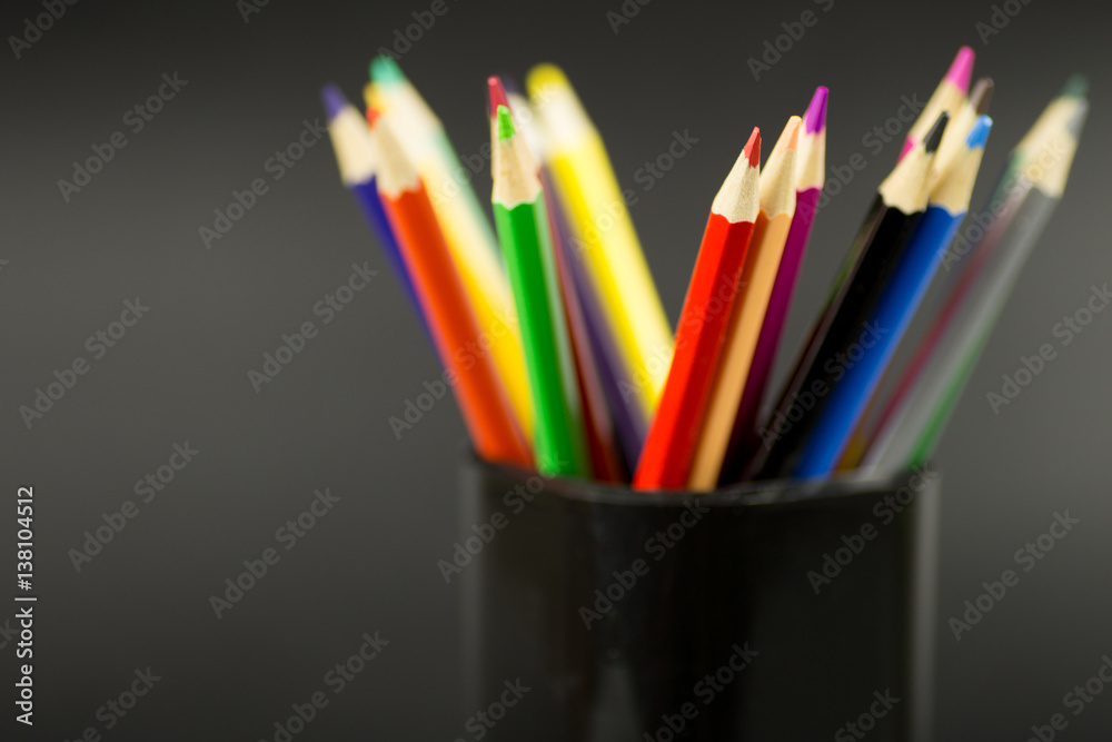 Obraz premium colored pencils on black background