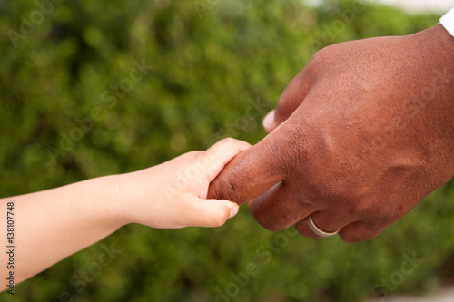 Father and son holding hands. Multicultural family.