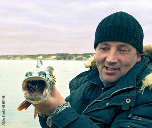 A man holding a pike with open mouth