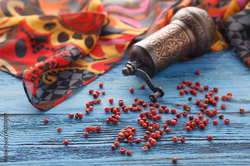 Red pepper on blue wooden table with silk scarf