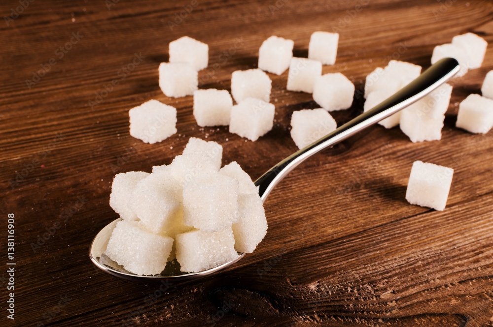 Diabetes. A lot of sugar cubes in spoon Diabetes. A lot of sugar cubes in spoon