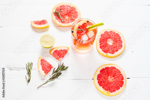 Refreshing homemade grapefruit and rosemary cocktail on white wooden table