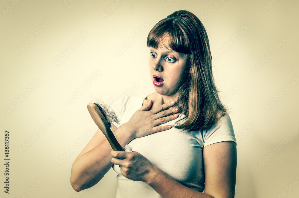 Woman with hairbrush is suffering from hair loss Woman with hairbrush is suffering from hair loss