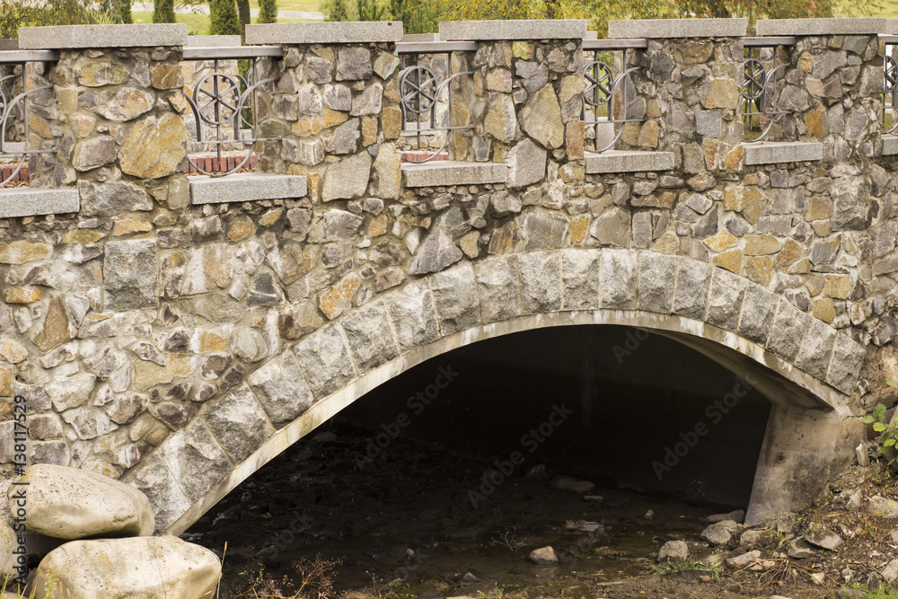 The old stony bridge in leaves forest