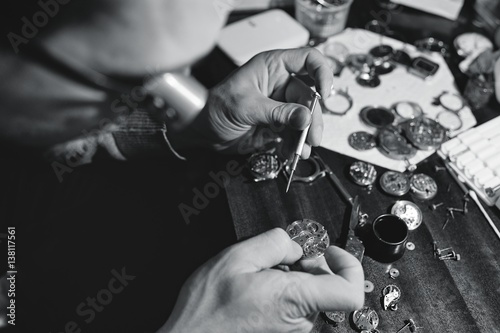 portrait of watchmaker repairing a watch photo