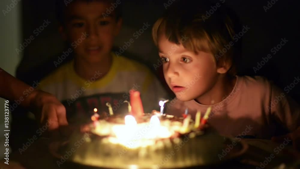 Happy kid blowing candles at his anniversary Happy kid blowing candles at his anniversary