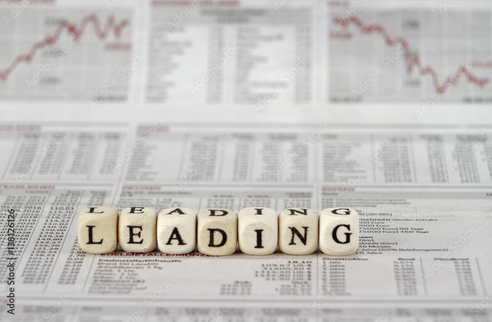 Leading word built with letter cubes on newspaper background