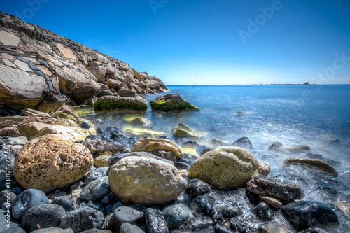 Rocks and blue waters at a beach in LImassol Cyprus photo