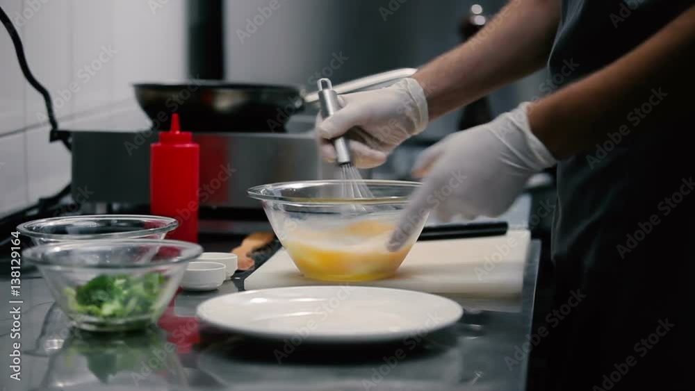 Man whips whisk eggs with milk in glass bowl. Man whips whisk eggs with milk in glass bowl.