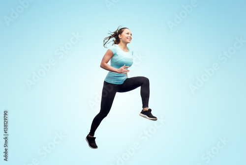 happy smiling sporty young woman jumping in air