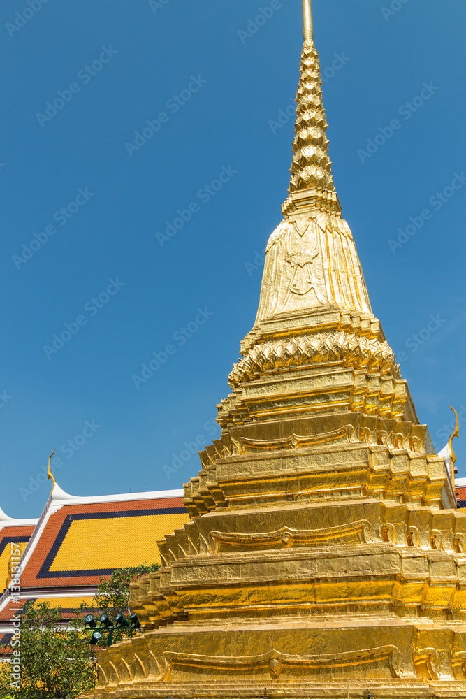 Fototapeta premium Wat Phra Kaew, Temple of the Emerald Buddha with gold pagoda and blue sky, Bangkok, Thailand