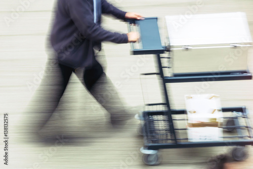 blurry to view of man transporting merchandise in a street