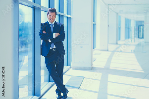 Portrait of businessman standing near window in office © lenets_tan