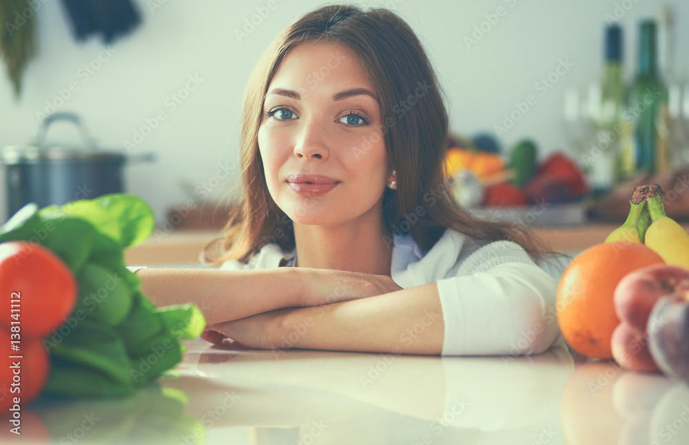 Young woman standing near desk in the kitchen Young woman standing near desk in the kitchen