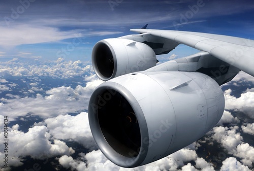 Airplane turbine engine from window view with cloudy sky