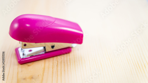 pink stapler on wood