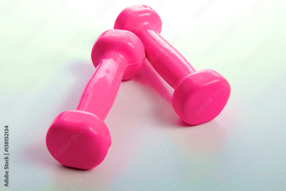 Two pink glossy dumbbell isolated on white Two pink glossy dumbbell isolated on white