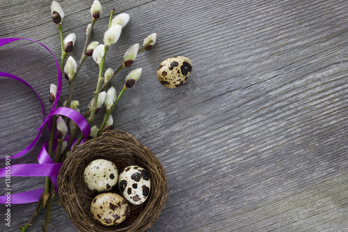 Easter eggs and willow branches on wooden desk. Easter background.