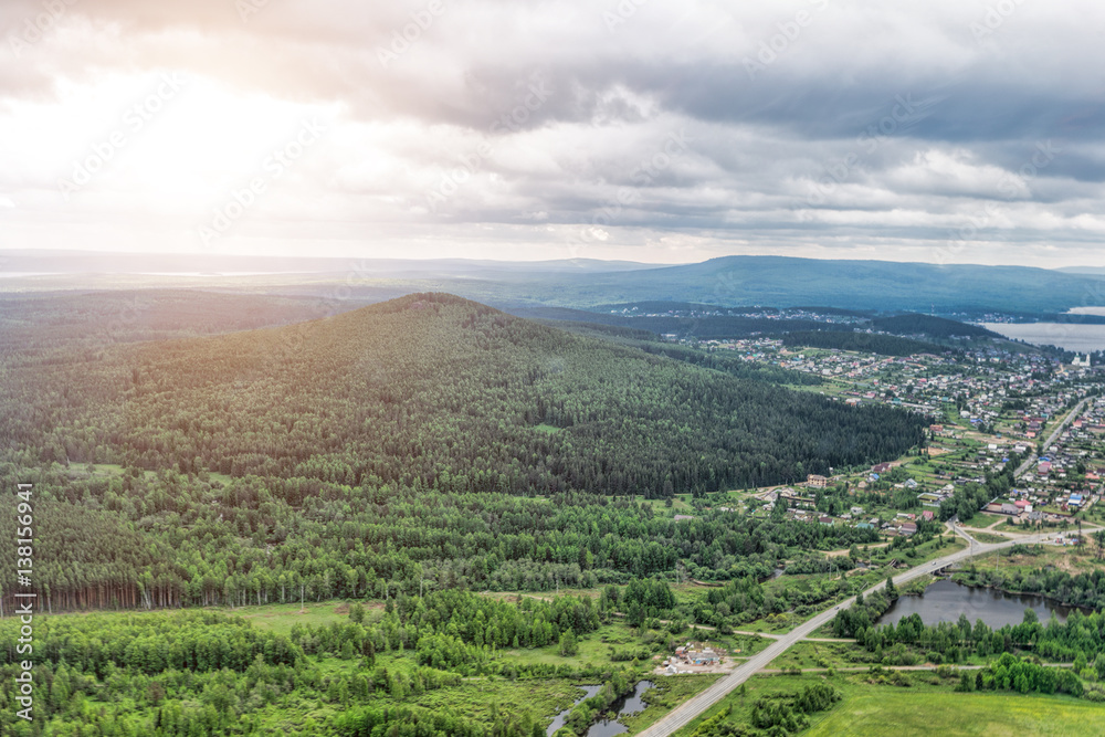 Urban panorama aerial view. City surrounded by forest