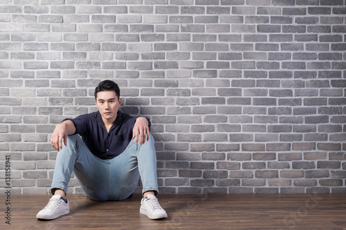 man sit with brick wall photo