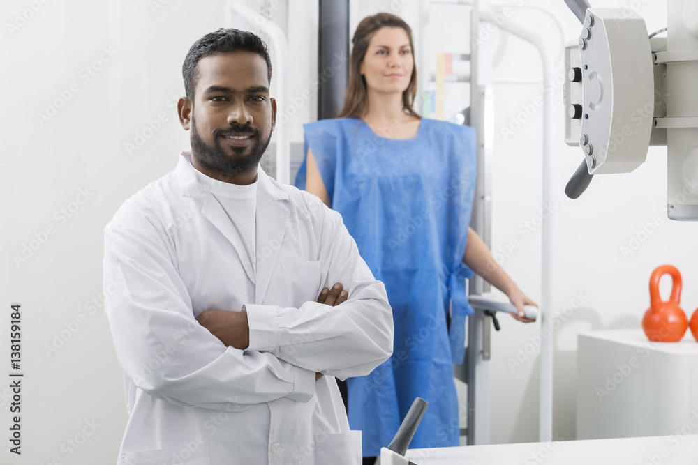 Obraz premium Male Radiologist Standing Arms Crossed In Examination Room