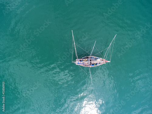 Fishing boat floating in the sea. The beautiful bright blue water in a clear day.