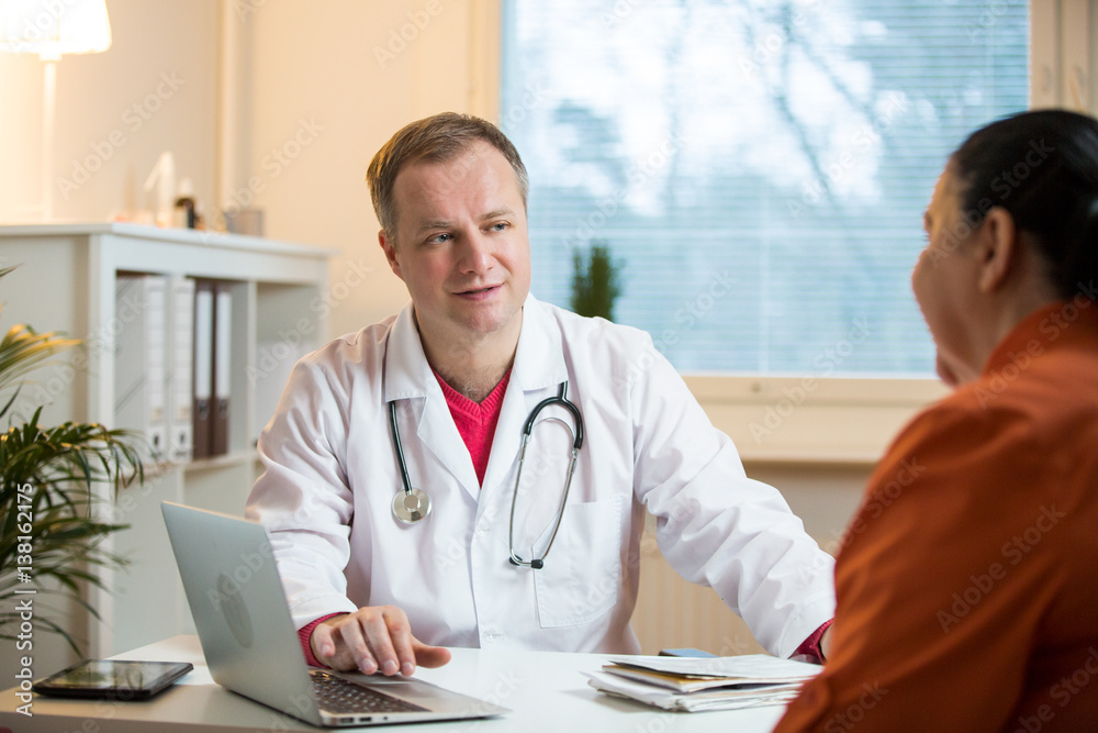 Smiling male doctor holding hand of patient in hospital. Sick senior woman having a doctor appointment. Trust and support concept. Smiling male doctor holding hand of patient in hospital. Sick senior woman having a doctor appointment. Trust and support concept.