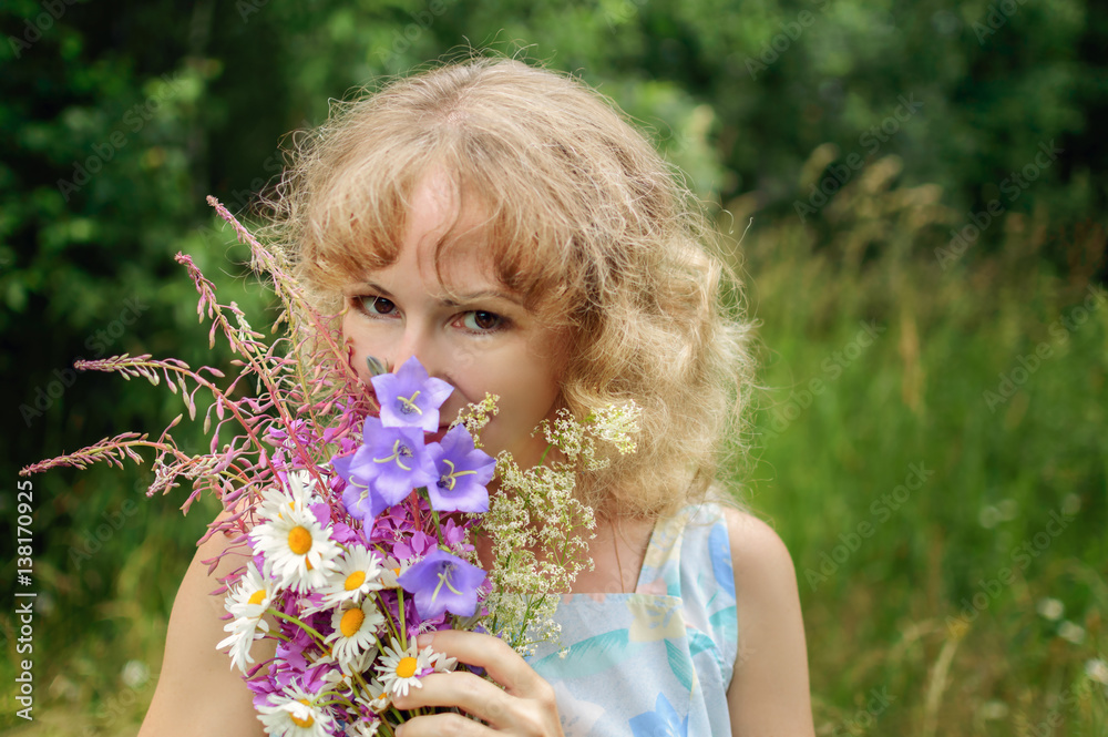 Young blonde woman with bouquet of wild flowers Young blonde woman with bouquet of wild flowers