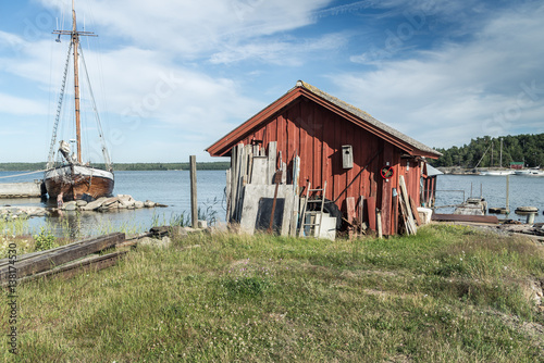 Red fisherman s hut and a sailing boat in Finnish archipelago.