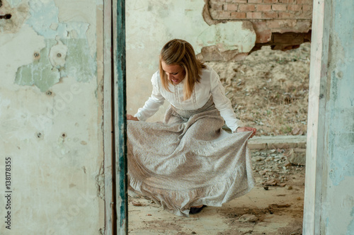 Mujer en habitacion derruida haciendo reverencia © Jonás Torres