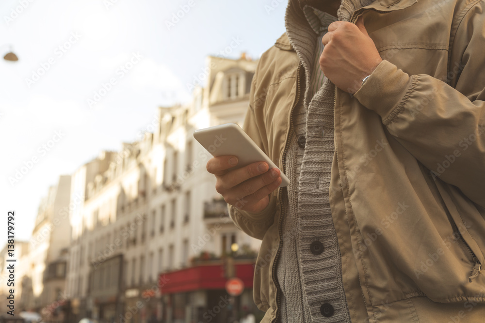 Modern guy using smartphone in the European city.
