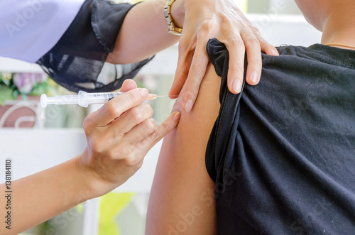 Doctor woman giving a child injection in arm