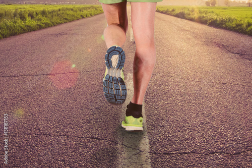 Legs closeup of man running on the road photo