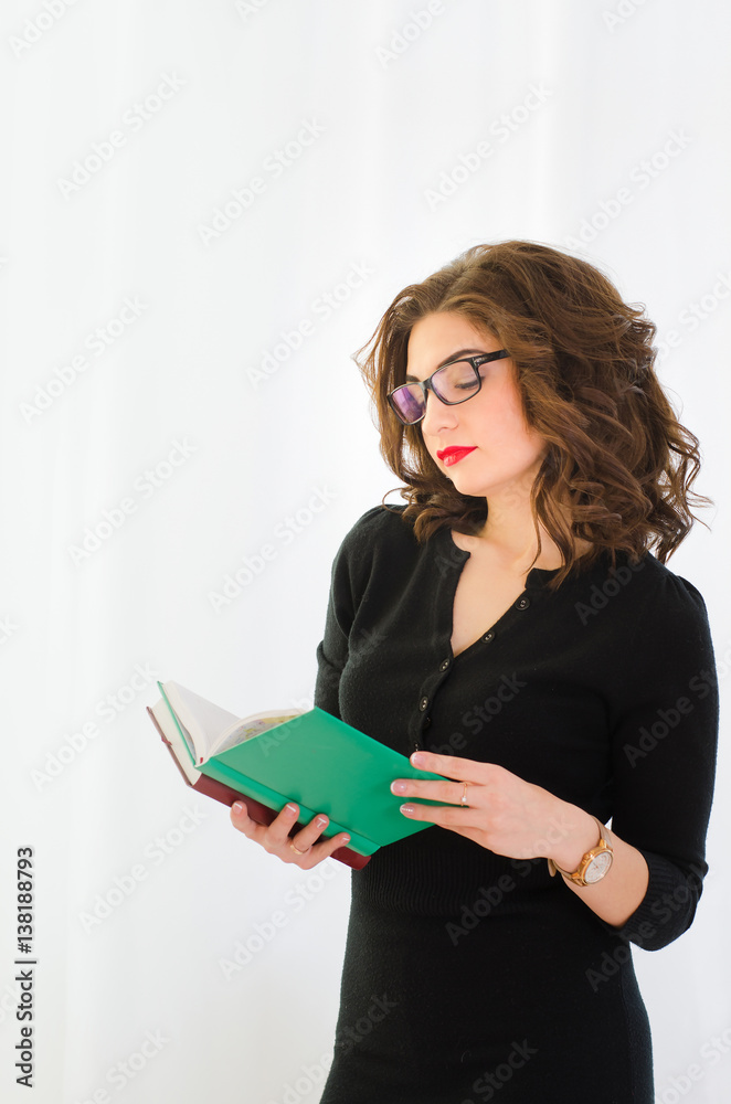 Attractive, professional businesswoman looking at diaries in hand Attractive, professional businesswoman looking at diaries in hand