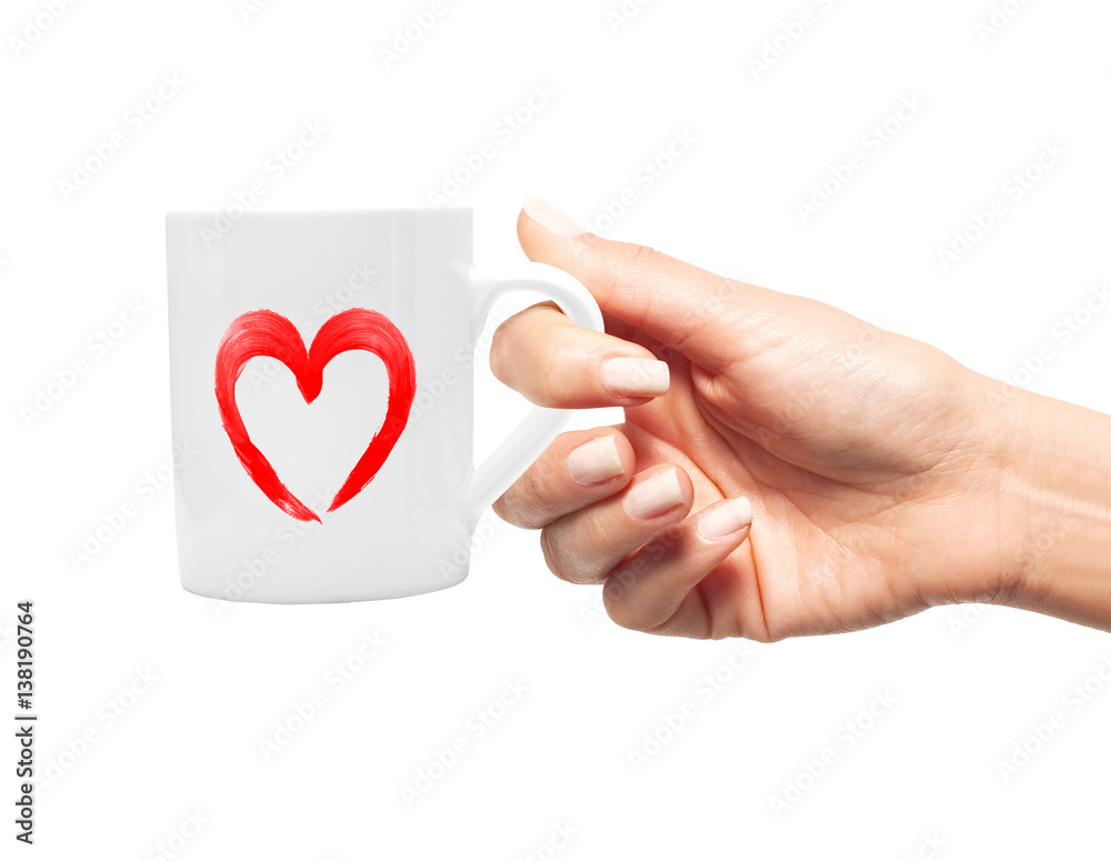 Woman hand with white cup of coffee and red heart Woman hand with white cup of coffee and red heart