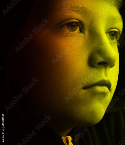 Young boy with his face illuminated by a video game