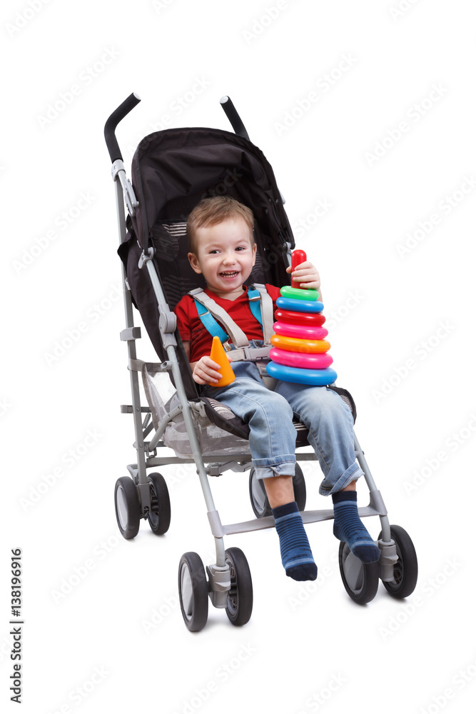 Smiling child is sitting in pram playing toy Smiling child is sitting in pram playing toy