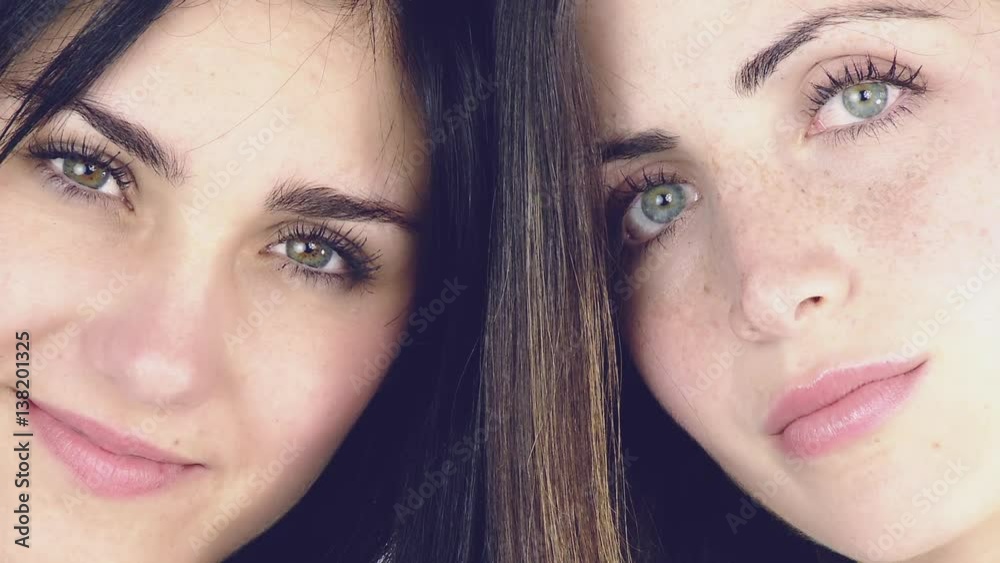 Closeup of two beautiful young women with green eyes smiling Closeup of two beautiful young women with green eyes smiling