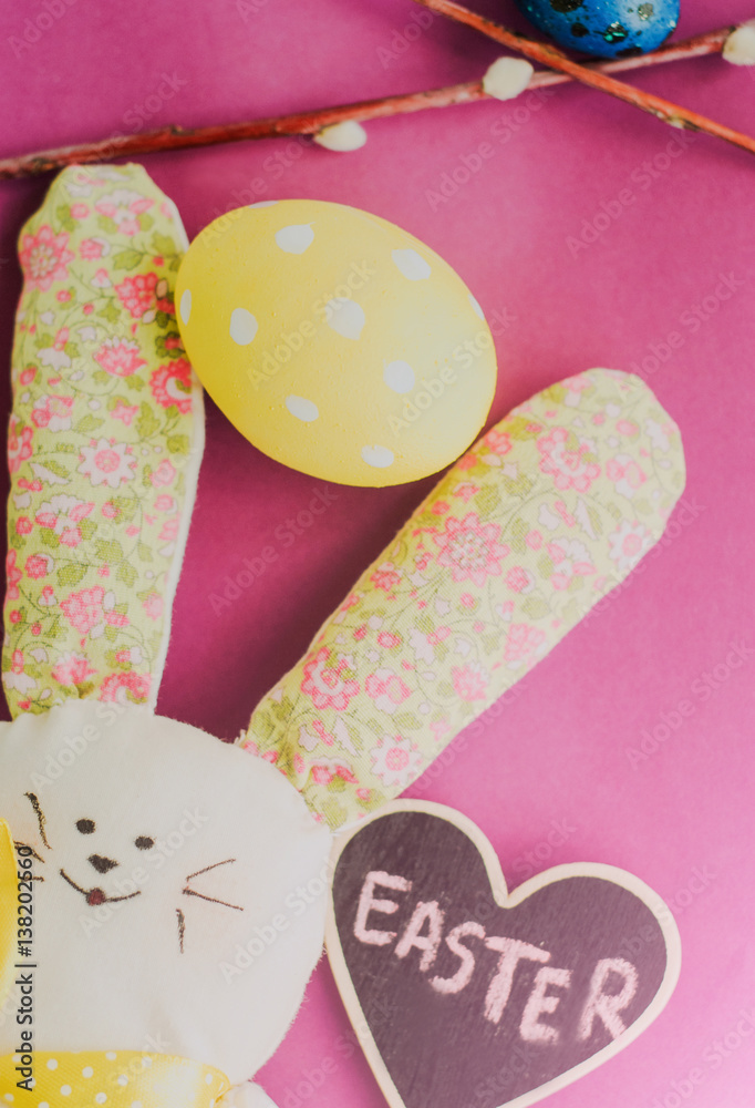 Colourful Easter eggs and a bunny on pink background